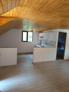 una stanza vuota con una cucina e un soffitto in legno di Ivan's House Cornereva a Cornereva Altre 8 foto