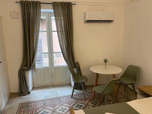 a room with a table and chairs and a window at Appartamenti Tiffany & Timi in Carini