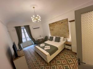 a hotel room with a bed and a chandelier at Appartamenti Tiffany & Timi in Carini