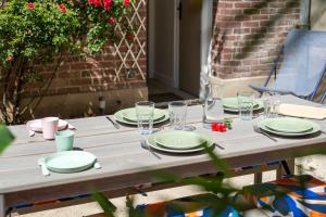 un tavolo di legno con piatti e bicchieri sopra di Le Cotin des Cordiers 1, F3 avec SA PLACE DE PARKING INCLUS a Le Tréport Altre 17 foto