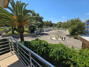 a balcony with a palm tree and a parking lot at Villa Relax Apartments in Budva