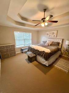 a bedroom with a bed and a ceiling fan at The Plush Retreat Marietta With Soaker Tub Walk In Closet in Marietta