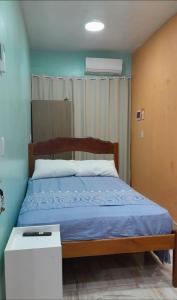 une chambre avec un lit recouvert d'une couette bleue dans l'établissement Meu refúgio, à Belém 11 autres photos