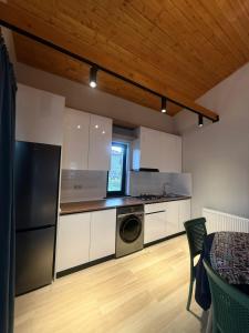 Bakurianis AndezitiCottage ANKANAKEBA的配有白色橱柜、洗衣机和烘干机的厨房