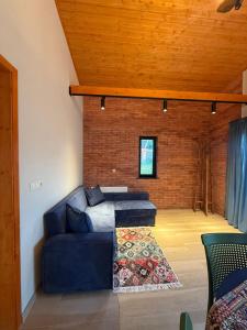 Bakurianis AndezitiCottage ANKANAKEBA的客厅设有蓝色的沙发和砖墙