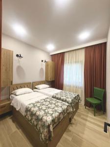 Bakurianis AndezitiCottage ANKANAKEBA的一间卧室配有一张大床和一张绿色椅子