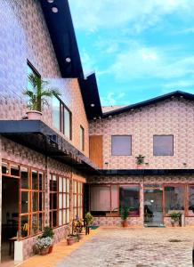 巴特那Hotel Aurelia Pearl的一座砖砌的大建筑,上面有盆栽植物