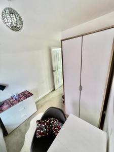 a room with a white cabinet and a chair at Private room in BS14 in Bristol