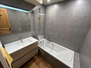 a bathroom with a sink and a bath tub at Appartement clos du linga pieds des pistes du LINGA in Châtel