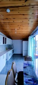 a kitchen with a table and chairs and a wooden ceiling at Likya Vadi Evleri Nature and tranquility in Antalya