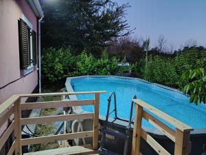 a swimming pool with two benches next to a house at Beautiful nearby beach house with garden, private pool and large yard in Sidari
