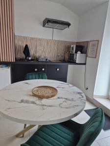 a kitchen with a table and two green chairs at La longère du Moulin in Basse-Goulaine +3 photos