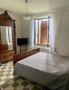 a bedroom with a large bed and a window at La Corte dei Lillà in Castiglione dei Pepoli