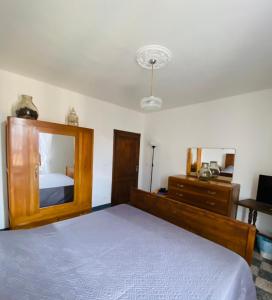 a bedroom with a bed and a dresser and a mirror at La Corte dei Lillà in Castiglione dei Pepoli