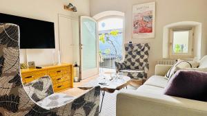 a living room with a couch and a tv at Borgo dei Sogni - Deluxe Apartment - Lago di Garda in San Felice del Benaco