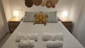 a bedroom with a bed with two lamps and two towels at Apartamento Sabimar Playa in San Luis de Sabinillas