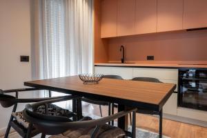a kitchen with a wooden table with chairs and a counter at Duplex Penthouse with Jacuzzi in Sarandë +43 photos
