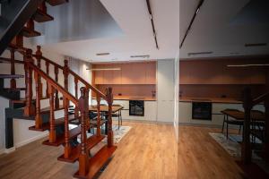 a living room with a staircase and a dining room at Duplex Penthouse with Jacuzzi in Sarandë