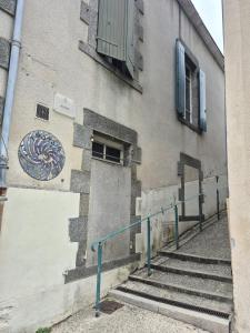 プゾージュにあるMaison centre-ville Pouzaugesの階段、ドア、窓のある建物 +3枚の写真