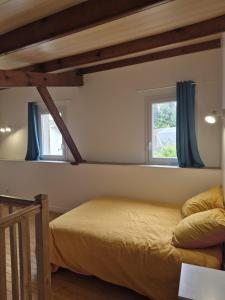 プゾージュにあるMaison centre-ville Pouzaugesのベッドと2つの窓がある寝室