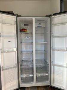 a white refrigerator with its doors open and its shelves at Villa Tamaris in Glanon