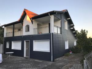 a black and white house with a balcony at Villa Tamaris in Glanon