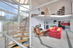 un salon avec un escalier et un canapé rouge dans l'établissement Villa Stella Australis 4 étoiles, à Petite Île