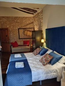 a bedroom with a large bed with blue and red pillows at Casa Rural el Castillico in Yecla