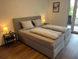a bedroom with a bed with two pillows on it at Jellys Apartment - 70qm - Balkon - Küche - Parken - 2x smart TV - King Size Bett - nur 5min zum Europa Park in Rheinhausen