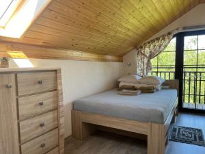 a bedroom with a bed and a wooden ceiling at Słoneczne Dęby in Debina
