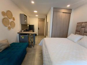 Simón BolivarにあるApartamento Santa Marta Sector Don Jacaの大きなベッドと青いソファのある寝室