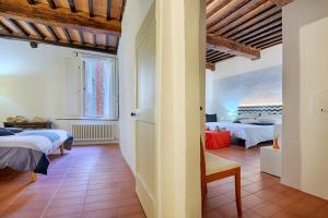 a room with two beds and a hallway with two beds at Le Loggine del Pignattello in Siena