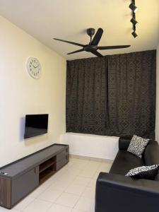 a living room with a couch and a ceiling fan at AH Comfy Home in Gua Sai