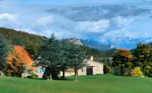 a house in a field with trees and mountains at Gîte Les Ailliers in La Chaudière