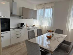 a kitchen with a table and chairs and a kitchen with a window at Villa Green s bazenom in Medulin