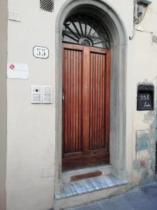 una puerta de madera en el lateral de un edificio en La Divina Dimora, en Florencia