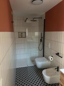 a bathroom with a tub and a toilet and a sink at KasaKìna in Marsala