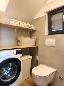 Un pequeño baño con lavadora y WC. en Awesome sea view, vacation home Jerula 2, en Milna