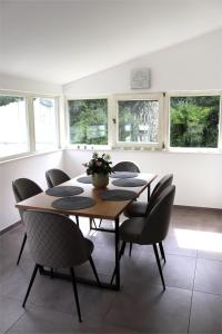 a dining room with a table and chairs and windows at Schöne Ferienwohnung vor den Toren Pullman Citys drei in Aicha vorm Wald