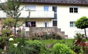 a garden in front of a white house at Schöne Ferienwohnung vor den Toren Pullman Citys drei in Aicha vorm Wald