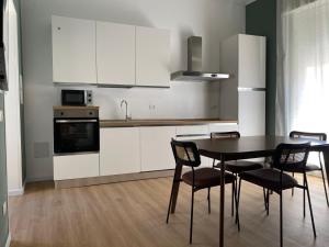 a kitchen with white cabinets and a table and chairs at KasaKìna in Marsala +15 photos
