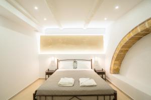 a bedroom with a bed with two towels on it at Rethymno Dome Garden in Rethymno