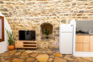 a kitchen with a refrigerator and a stone wall at Rethymno Dome Garden in Rethymno