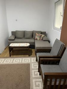 a living room with a couch and a coffee table at Ušuškana kućica "Gočka" in Mataruška Banja