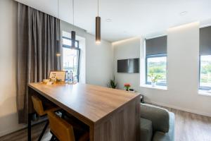 an office with a wooden desk in a room with windows at Urban Nest by Arena and Stadium in Kaunas