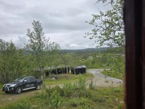 a black truck parked in a field next to a road at Utsikten in Geilo