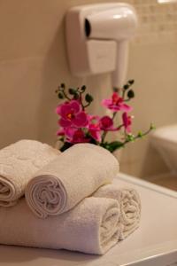 Una pila de toallas sobre el mostrador del baño con flores. en DODI GREEN apartment, en Arad 25 fotos más