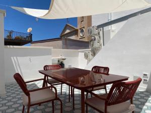 a wooden table and chairs on a patio at KasaKìna in Marsala
