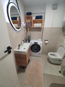 a bathroom with a sink and a toilet and a mirror at Apartman Jež 4 De Lux - self check in, free parking in Karlovac