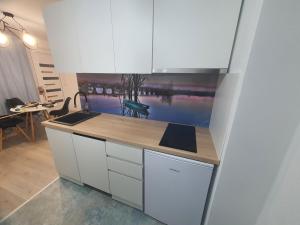 a kitchen with white cabinets and a counter top at Apartman Jež 4 De Lux - self check in, free parking in Karlovac